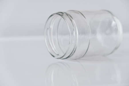Empty glass transparent jar on a white table. Copy, empty space for text.の写真素材