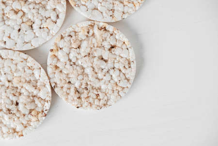 Round diet crispbreads on a white background. Round shaped cereal bread, healthy food without yeast. Top view. Copy, empty space for text.の写真素材