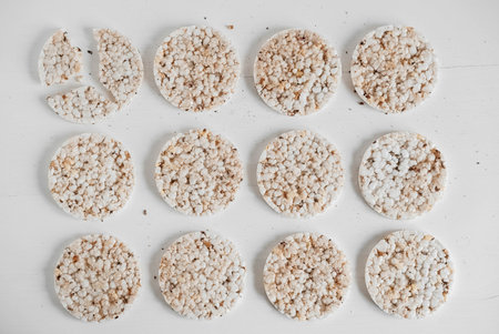 Round diet crispbreads on a white background. Round shaped cereal bread, healthy food without yeast. Top view. Copy, empty space for text.の写真素材