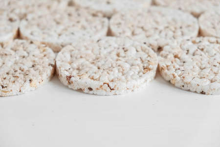 Round diet crispbreads on a white background. Round shaped cereal bread, healthy food without yeast. Top view. Copy, empty space for text.の写真素材