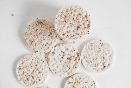 Round diet crispbreads on a white background. Round shaped cereal bread, healthy food without yeast. Top view. Copy, empty space for text.の写真素材