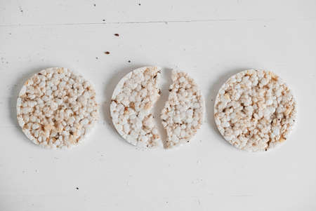 Round diet crispbreads on a white background. Round shaped cereal bread, healthy food without yeast. Top view. Copy, empty space for text.の写真素材