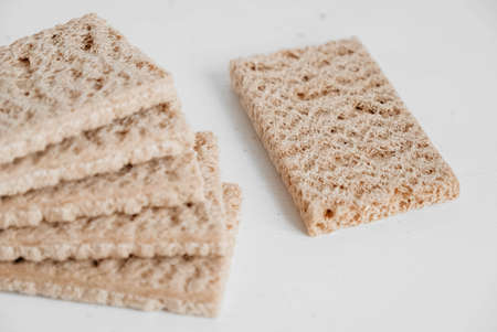 Stacked rye crisp bread on a white wooden background. Copy, empty space for text.の写真素材