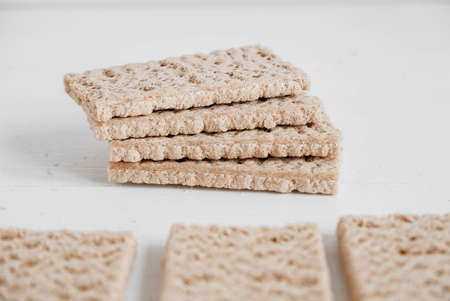 Stacked rye crisp bread on a white wooden background. Copy, empty space for text.の写真素材