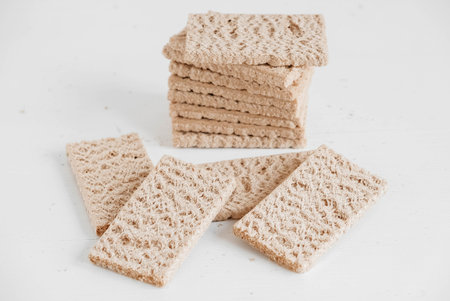 Stacked rye crisp bread on a white wooden background. Copy, empty space for text.