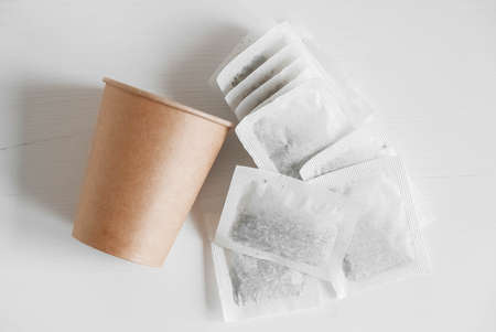 Paper cup and bags with tea on a white background. Top view. Copy, empty space for text.の写真素材