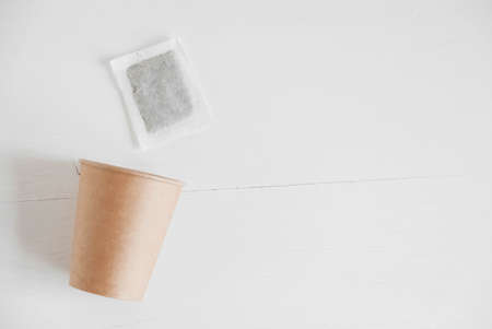 Paper cup and square dry tea bag on a white background. Top view. Copy, empty space for text.の写真素材