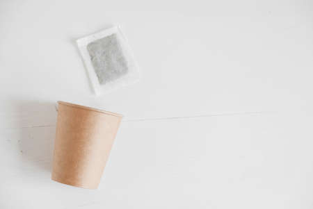 Paper cup and square dry tea bag on a white background. Top view. Copy, empty space for text.の写真素材