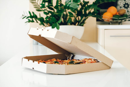 Pizza in a cardboard box on a white table background. Copy, empty space for text.の写真素材