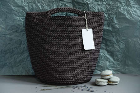 Toy teddy bear with a knitted bag on a brown background. Copy, empty space for text.の写真素材