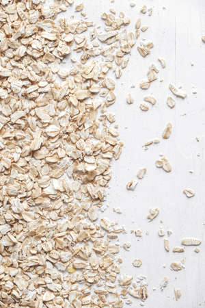 Dry oatmeal is randomly scattered on a white background. Top view. Copy, empty space for text.の写真素材