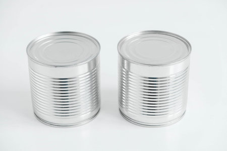 Two aluminum closed metal cans on a white table. Copy, empty space for text.の写真素材