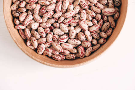 Raw dry beans in a wooden bowl on a white background. Top view. Copy, empty space for text.の写真素材