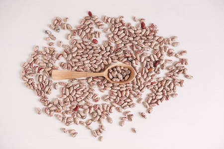Raw dry beans in a wooden spoon scattered on a white background. Top view. Copy, empty space for text.の写真素材