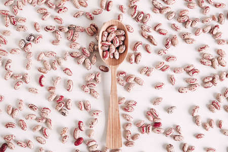 Raw dry beans in a wooden spoon scattered on a white background. Top view. Copy, empty space for text.の写真素材