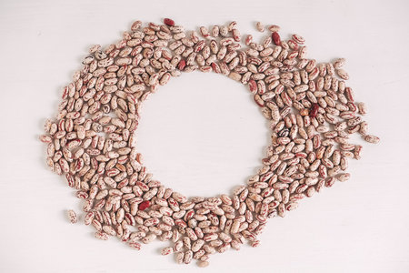 Raw beans scattered on a white table background. Top view. Copy, empty space for text.