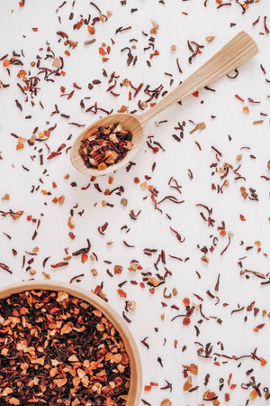 Dry fruit tea in a wooden spoon and a wooden plate on a white background. Top view. Copy, empty space for text.の写真素材