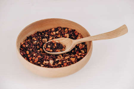 Dry fruit tea in a wooden spoon and a wooden plate on a white background. Top view. Copy, empty space for text.の写真素材