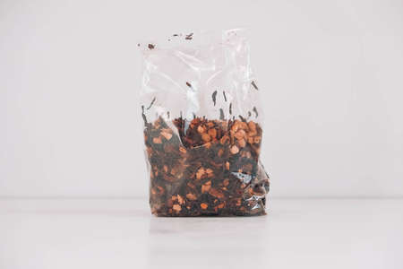 Dry fruit tea in a transparent plastic bag on a white table background. Copy, empty space for text.の写真素材