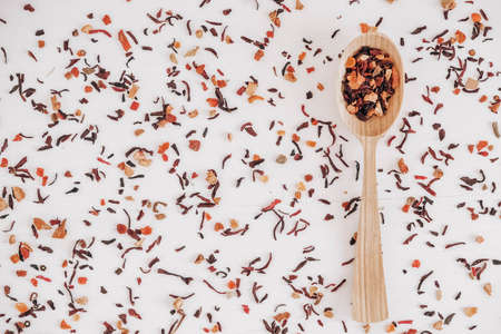 Dry fruit tea in a wooden spoon scattered on a white background. Top view. Copy, empty space for text.の写真素材