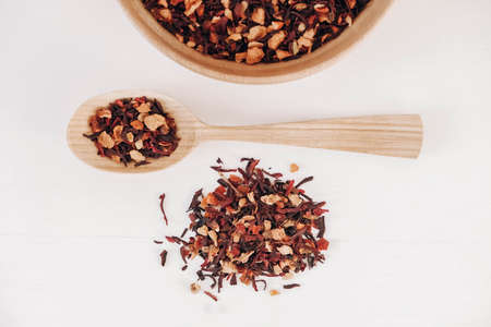 Dry fruit tea in a wooden spoon scattered on a white background. Top view. Copy, empty space for text.の写真素材