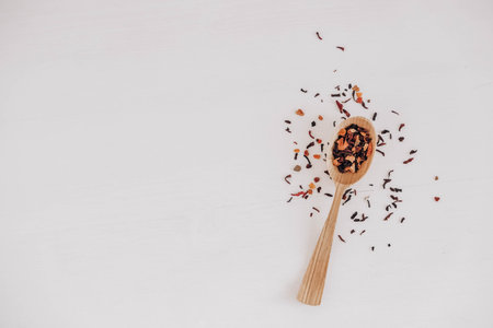 Dry fruit tea in a wooden spoon scattered on a white background. Top view. Copy, empty space for text.の写真素材