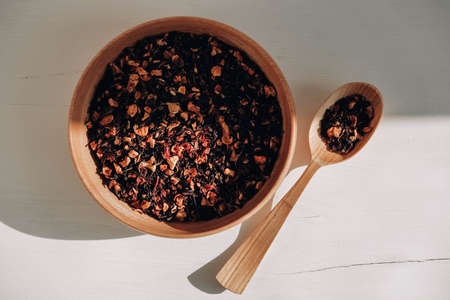 Dry fruit tea in a wooden spoon and a wooden plate on a white background. Top view. Copy, empty space for text.の写真素材