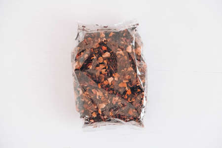 Dry fruit tea in a transparent plastic bag on a white table background. Top view. Copy, empty space for text.の写真素材