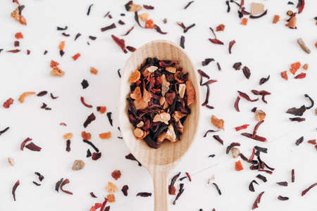 Dry fruit tea in a wooden spoon scattered on a white background. Top view. Copy, empty space for text.の写真素材