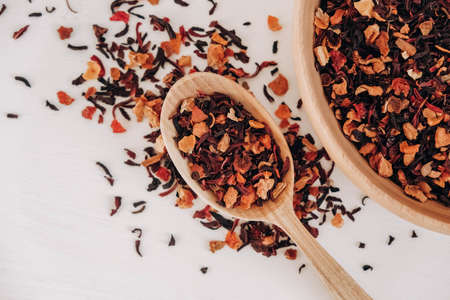 Dry fruit tea in a wooden spoon scattered on a white background. Top view. Copy, empty space for text.の写真素材