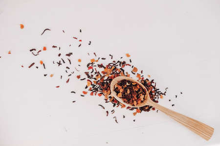 Dry fruit tea in a wooden spoon scattered on a white background. Top view. Copy, empty space for text.の写真素材