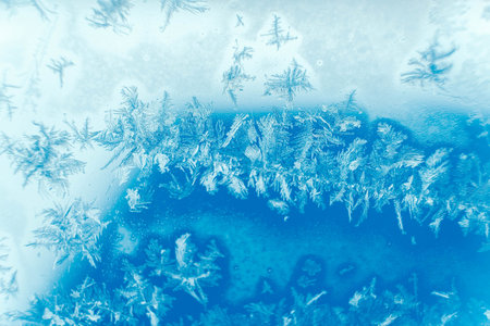 Ice patterns on frozen glass. Abstract ice pattern on winter glass as a background image. Copy,...