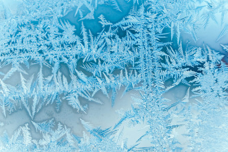 Ice patterns on frozen glass. Abstract ice pattern on winter glass as a background image. Copy,...