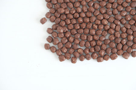 Chocolate corn balls scattered on a white background. Top view. Copy, empty space for text.