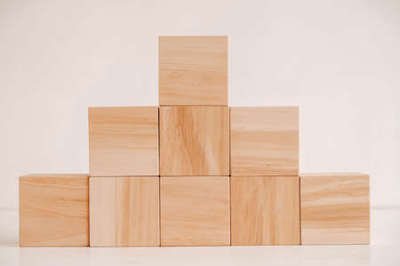 Pyramid of wooden blocks from natural wood on a white background. Copy, empty space for text.の写真素材