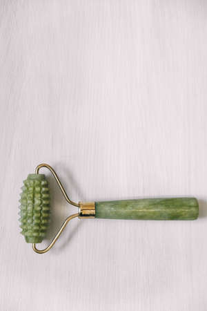One massage roller made of green jade stone on a white background. Top view. Copy, empty space for text.の写真素材