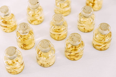 Flasks with gold samples on a white background. Copy, empty space for text.