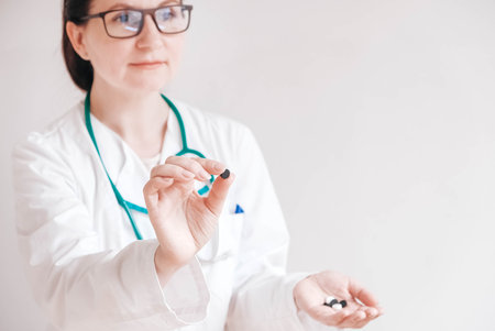 Beautiful woman doctor pills in her hands on a white background. Taking vitamins or medications. Copy, empty space for text.の写真素材