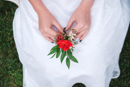 Boutonniere for wedding in the hands of a girl bride in a white dress. Copy, empty space for text.の写真素材