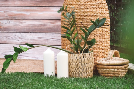 Rustic decorated with wooden background, hay, wicker pots with plants, lamps and candles. Copy, empty space for text.の写真素材