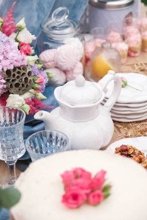 Banquet dessert table decorated in a rustic style decorated with plates, cutlery, glasses, candles and flower arrangements. Copy, empty space for text.の写真素材