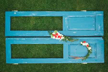 Decorated wreath of flowers, leaves and dry grass on a wooden blue door background. Copy, empty space for text.の写真素材