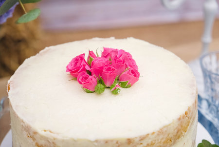 White wedding cake decorated by flowers standing of festive table. Copy, empty space for text.の写真素材