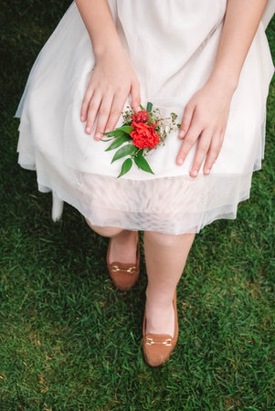 Boutonniere for wedding in the hands of a girl bride in a white dress. Copy, empty space for text.の写真素材