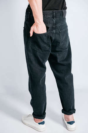 Back pocket of black jeans. Man s hand in the back pocket of jeans. Copy, empty space for textの写真素材
