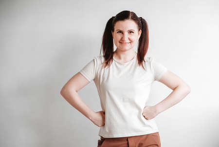 Woman with pigtails and a funny face wearing a T-shirt on a white background. Copy, empty spaceの写真素材
