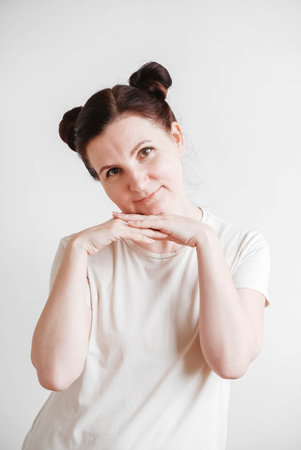 Woman with pigtails and a funny face wearing a T-shirt on a white background. Copy, empty spaceの写真素材