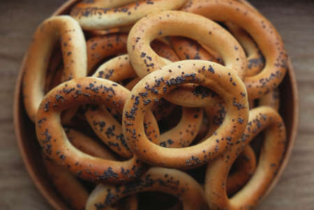 Dried bagels with poppy seeds in a wooden bowl.の写真素材