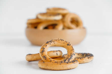 Dried bagels with poppy seeds in a wooden bowl on a white background.の写真素材