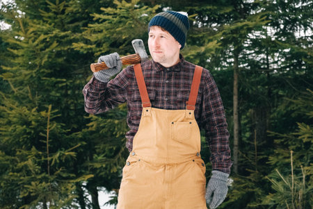 Portrait of a man lumberjack with an ax in his hands on a background of forest and trees
